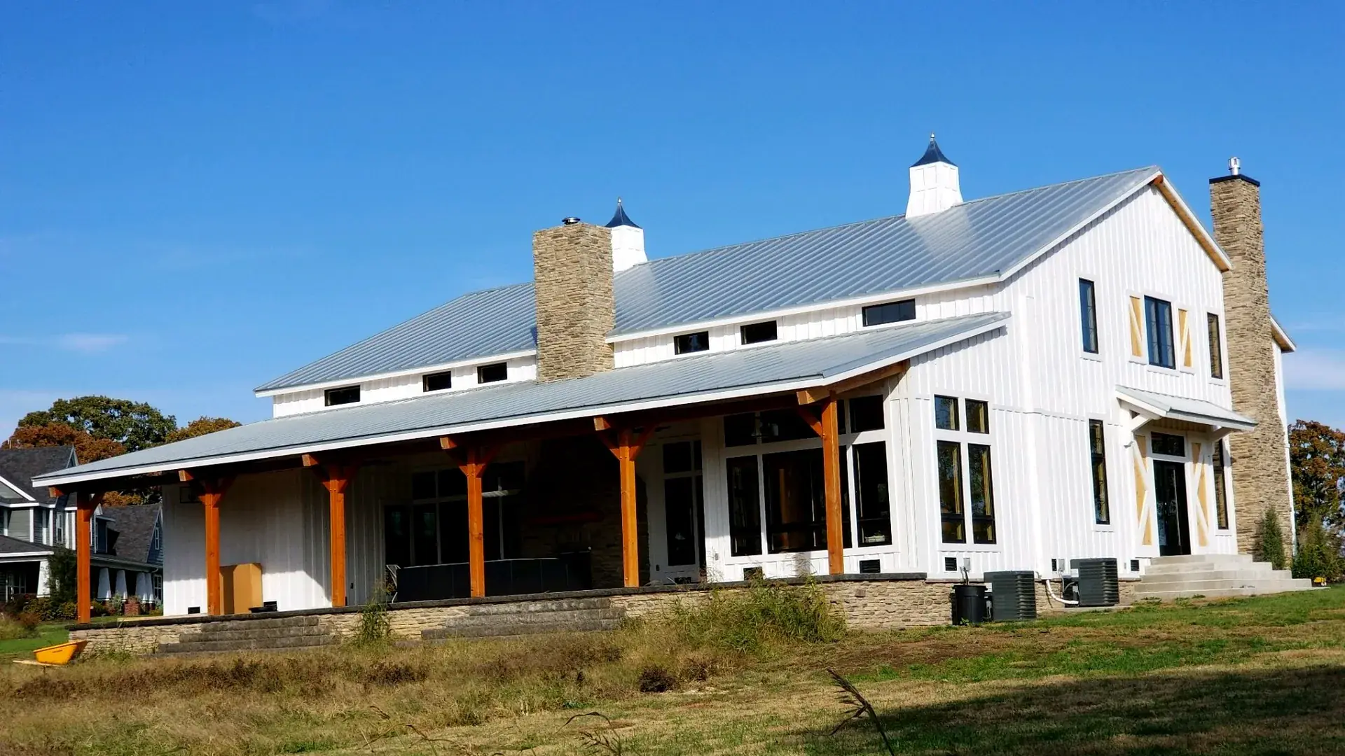 Premium barndominium with stone chimneys and timber frame porch in Wyoming