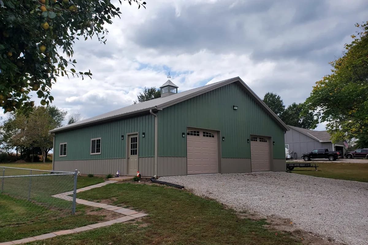 Green steel shop with cupola and attached garage bays in Wyoming